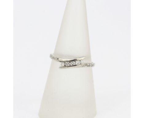 A 9ct white gold diamond set crossover ring, (N.5).