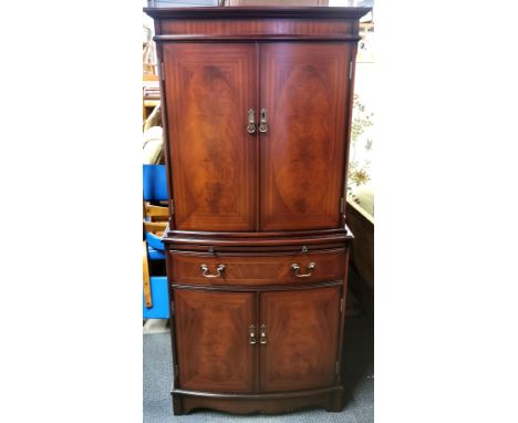 An inlaid mahogany drinks cabinet with mirrored interior, glass shelves and pull out cocktail platform, 152 x 70 x 43cm.