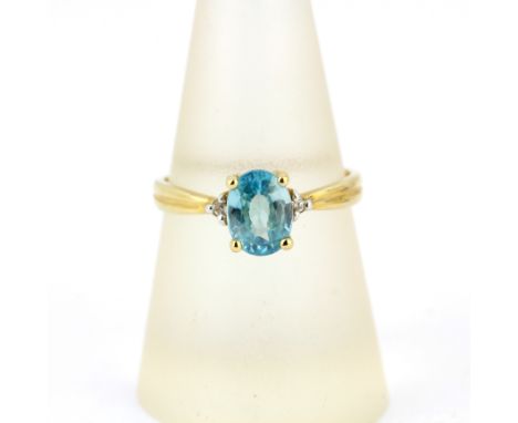 A 9ct yellow gold ring set with an oval cut blue topaz and diamonds, (Q).