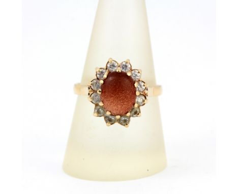 A 14ct yellow gold cluster ring set with cabochon cut sandstone and white stones, (S.5).