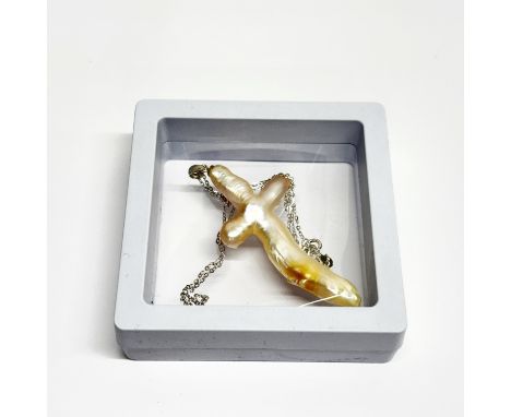 A cross shaped baroque cultured pearl pendant, L. 5.5cm, on a silver chain.