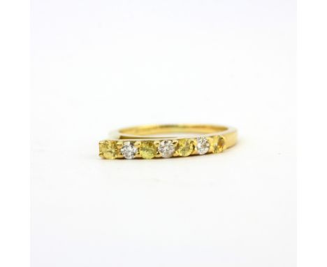 An 18ct yellow gold brilliant cut diamond and fancy yellow diamond set half eternity ring, (J).