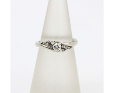 A 9ct white gold diamond set solitaire ring with diamond set shoulders, (J.5).