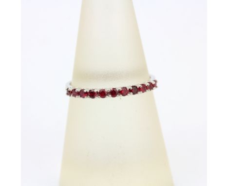 An 18ct white gold ruby set half eternity (N.5).