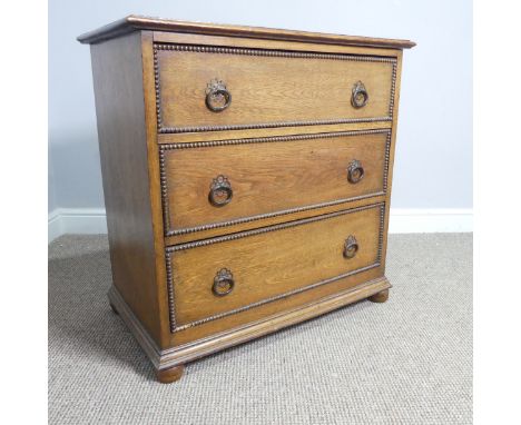 An Early 20th century oak Chest of Drawers, of three long drawers with decorative beading and handles upon tuned feet, note o