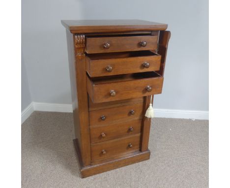 An early Victorian mahogany Wellington Chest, with seven drawers, carved brackets and turned wooden handles, raised on a plin