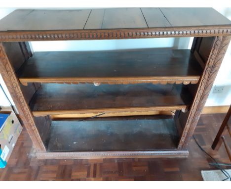 A Victorian oak two shelf bookcase with carved leaf decoration top has shrinkages to the panels15" x 47" x 41 "50/70