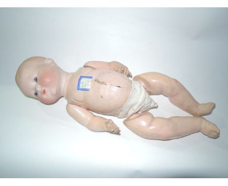 A vintage child's doll with bisque ceramic head with painted eye lashes and lips, with papier-mâché jointed body, with stamp 