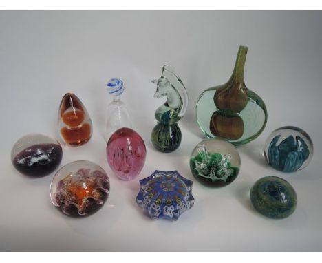 A selection of paperweights to include a Strathearn star shaped Millefiori example with canes in shades of ochre and yellow t