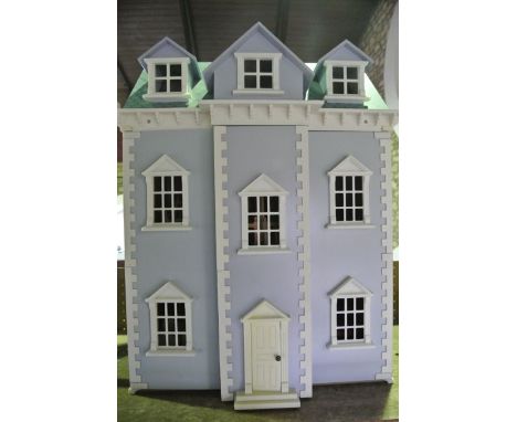 A substantial contemporary dolls house in the form of a Georgian manor, the façade centred by a front door with pointed pedim