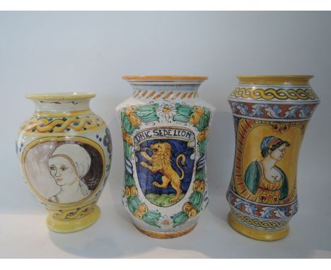 A collection of three continental maiolica vases comprising example with painted lion crest within fruited garland, example w