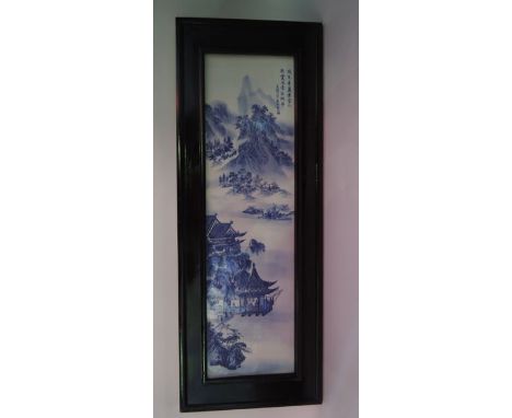 An oriental ceramic panel of rectangular form with blue and white decoration of a landscape with pagoda, mountains, etc, 74 x