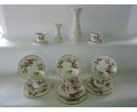 Two Belleek vases, both with relief moulded decoration of flowers and stems, and further painted shamrock design with dark bl