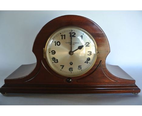 A mahogany mantle clock of Napolean hat form with three train movement retailed by Pleasance & Harper 