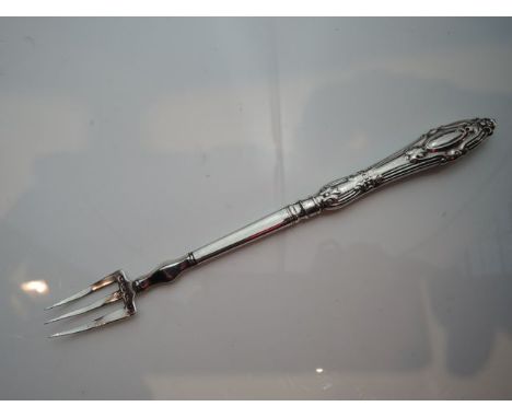 A Victorian silver pickle fork, Joseph Carnell, Birmingham, 1861, the handle moulded with scrolls and a vacant cartouche, 15c