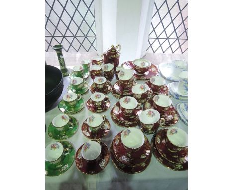 An extensive collection of Crown Staffordshire red ground tea and coffee wares with gilded, printed and infilled floral decor