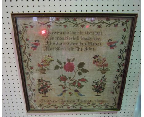 A mid-19th century framed and glazed sampler depicting a central study of a rose sprig flanked by symmetrical motifs of arran