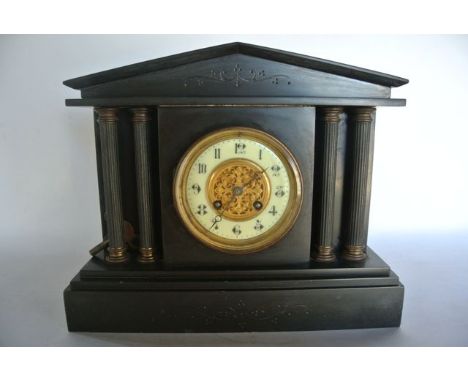 A Victorian black slate mantle clock of architectural form with striking movement