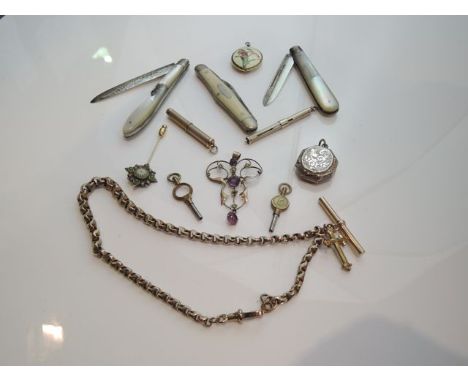 An Art Nouveau pendant, of scrolling open-worked form, centred with three graduated amethyst coloured stones, highlighted wit