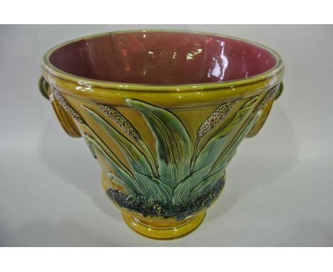 A large late 19th century majolica two handled jardinière of flared form with moulded ring handles and relief moulded and pai
