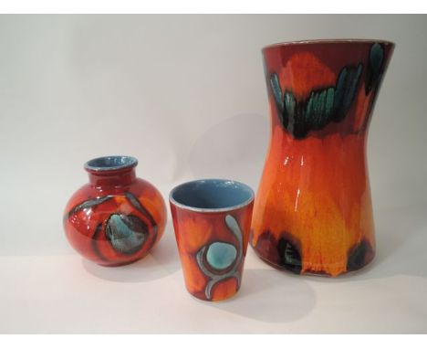 A collection of Poole Pottery wares with mottled orange, red and blue glaze comprising a vase of waisted form, a small vase o