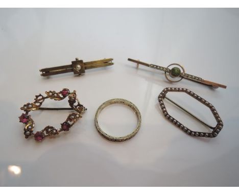 An Edwardian bar brooch, centred with a collet-set round mixed-cut peridot, flanked to either side with a row of seed pearls,