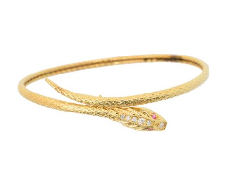 An 18ct gold snake bangle, designed as a textured snake with brilliant cut diamond crest and circular cut ruby eyes, French a
