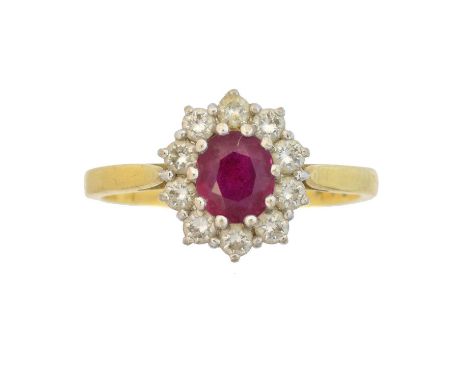 An 18ct gold ruby and diamond cluster ring, the oval shape ruby within a brilliant cut diamond surround, estimated total diam