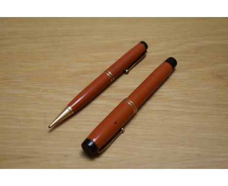 A Parker Duofold Special button fill fountain pen and propelling pencil in red with two bands to the cap having Parker Duofol