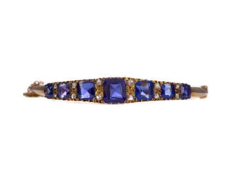 BLUE GEM SET AND DIAMOND BANGLE, set with cushion cut blue gems interspaced by pairs of rose cut diamonds, unmarked, with saf