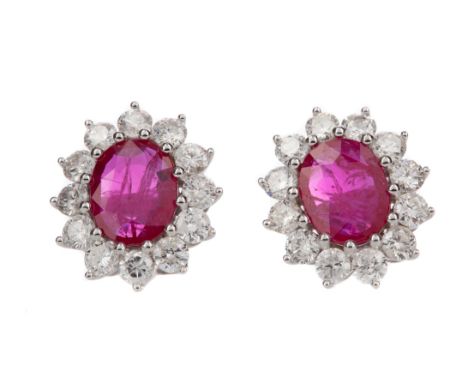 PAIR OF RUBY AND DIAMOND EARRINGS, the central oval rubies totalling approximately 3.56 carats, within round brilliant cut di