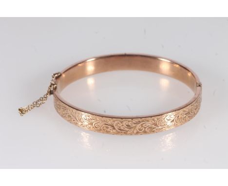 Early 20th century 9ct rose gold half engraved bangle, 9.8g, internal width 6.4cm, in original box.