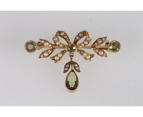 Edwardian 15ct gold peridot and seed pearl bar brooch, the bow form openwork frame studded with split pearls around round cut