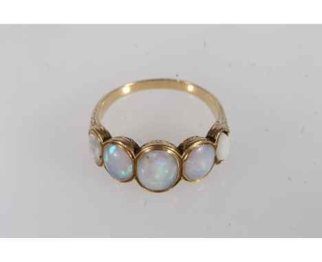 Early 20th century yellow metal and opal five stone ring, the graduated cabochon opals bezel set within a tapering plain band