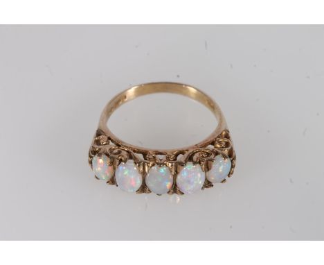 9ct gold and white opal five stone ring, the graduating oval cabochon opals on a scrolled mount, reeded shoulders leading to 