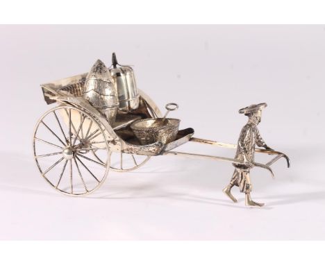 Chinese white metal three-piece cruet set, modelled in the form of a man pulling a rickshaw, fitted with pepper caster, open 