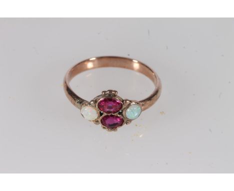 Early 20th century yellow metal pink stone and opal ring, the oval cut pink stones flanked by cabochon opals in a rub over se