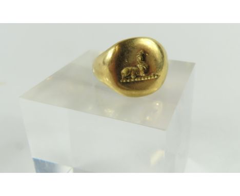 A seal engraved signet ring with worn engraving of a lion or griffin, finger size H1/2, acid tests as approximately 18-22ct g