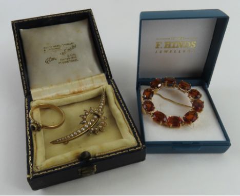 A late 19th or early 20th century split pearl brooch of a crescent moon through a flaming sun, 4.7cm long, marked '15ct', 4.2