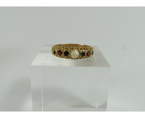A 15ct gold multi gemstone ring, set with a moonstone, two garnets and four emeralds, with decorative shoulders, finger size 