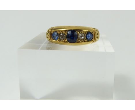 An early 20th century 18ct gold sapphire and diamond five stone ring, the three graduated sapphires with an old cut diamond b