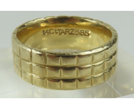 A wide gold band ring, with lined decoration throughout, finger size O1/2 centre, marked indistinctly '14ct', 9g gross