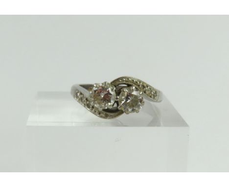 A mid-20th century diamond two stone twist ring, the two round brilliant cut diamond claw set and with small diamonds to the 