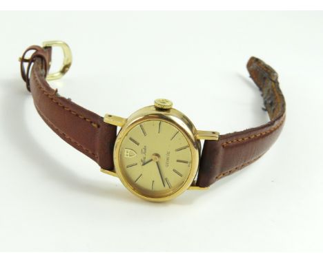 Miss Tudor - a ladies gold cased manual wind wristwatch, the oval gold dial with black baton hour markers and hands, on a lat