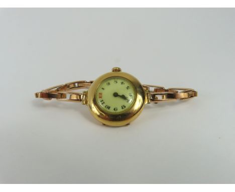 An 18ct gold cased early 20th century manual wind ladies wristwatch, the round white enamel dial with black Arabic hour marke