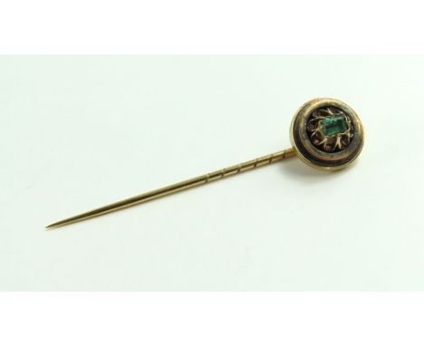 A 19th or early 20th century stock pin, the round head set with a single step cut emerald, 5.5cm long, 3.3g gross, acid tests