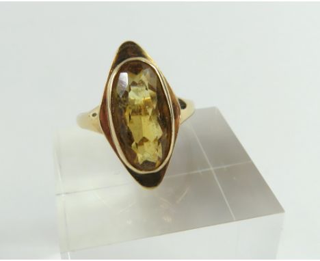 A 9ct gold citrine cocktail ring, elongated oval cut stone in a rub over setting, approximately 15.1mm x 7.8mm,  finger size 