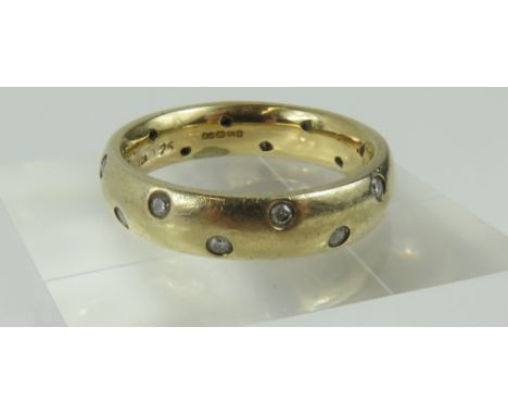 A 9ct gold diamond set band ring, the round cut diamonds set at intervals around the band, finger size O leading edge, marked