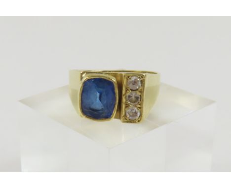 A contemporary design sapphire and diamond ring, the facetted rectangular shaped sapphire with rounded corners and in a rub o