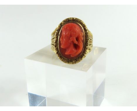 A 19th or possibly 18th century coral ring, the orange stone with a carved head and shoulders of a man in the classical style